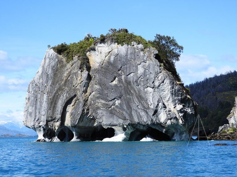 Gran roca con cuevas en el lago