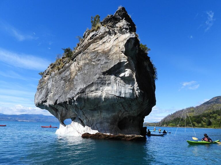 Gran roca y personas en kayak